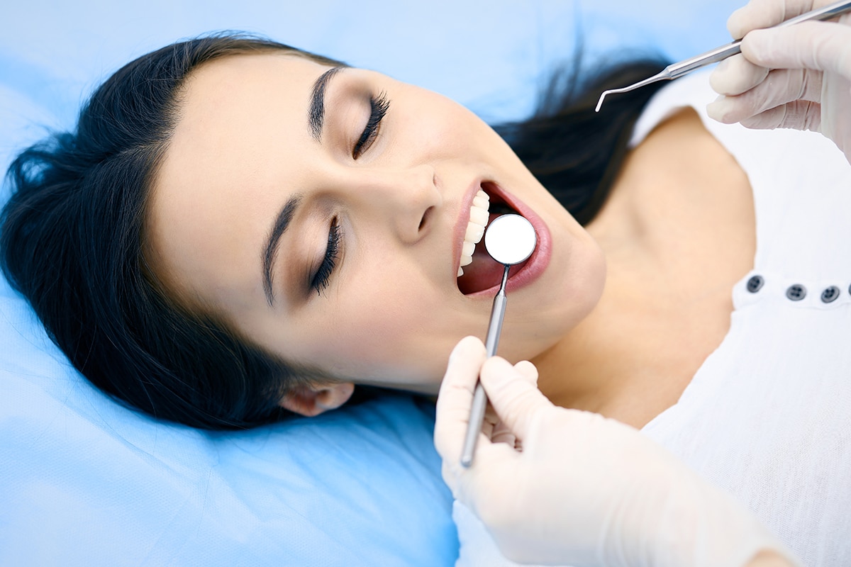 a woman at the dentist getting help for common dental issues