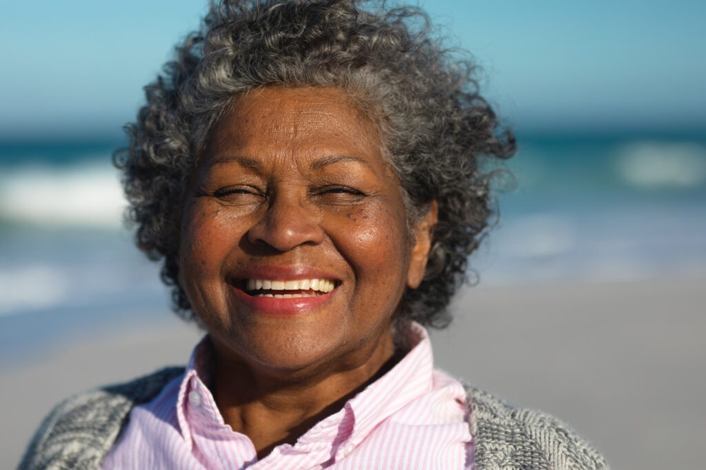 Old woman smiling at the beach